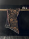 Black cotton throw blanket featuring woven bronze beetles and botanical motifs with multicolored fringe trim.